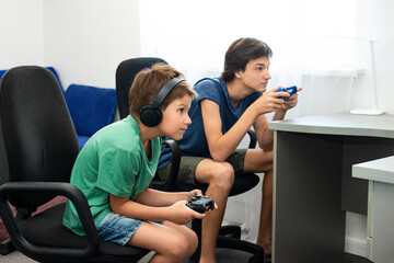 Teenager plays a computer game with headphones and a joystick, game console.