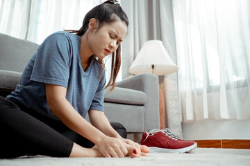 After workout of Young asian woman sitting foot pain between to exercise