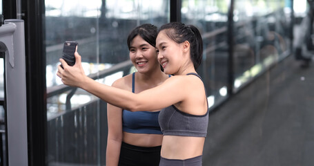 Sporty young asian women with friends taking picture of her friend