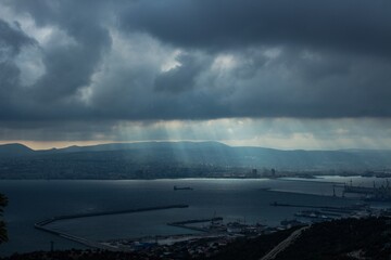 the rays of the sun make their way through the clouds to the city