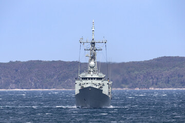 Navy warship heading into a harbor.
