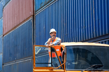 Foreman worker talking on the walkie-talkie for controlling loading container in container...