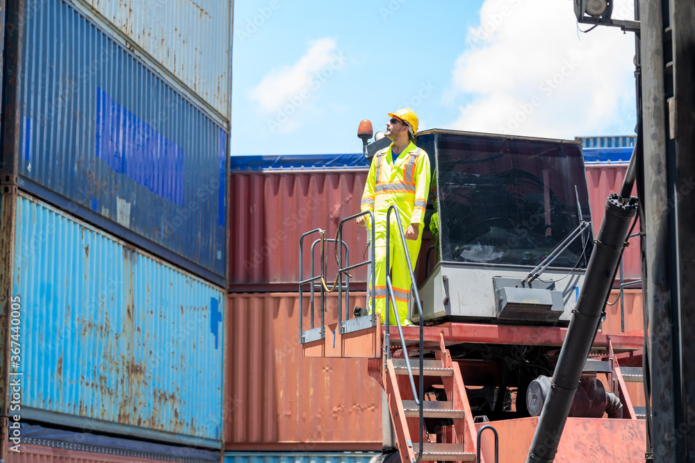 Poster serious dock worker controlling work processes in the port in container warehouse.
