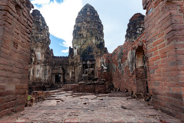 Naklejka premium The old castle and the Buddha statue are made of stone. There are many monkeys.
