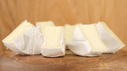 Camembert cheese close up. Rotation pieces of soft cheese Camembert. Delicious pieces of white mold cheeses with soft textures