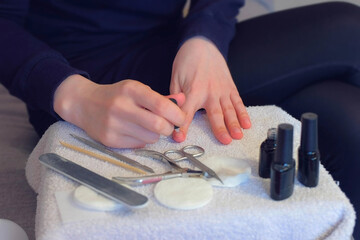 Woman is applying primer using brush on nails before cover it shellac gel polish, hands closeup....