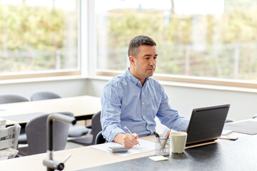 remote job, business and people concept - middle-aged man with calculator, papers and laptop...