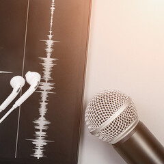 Podcast record. Microphone, headphone and sound track at tablet. Grey monochrome. Audiobook and...
