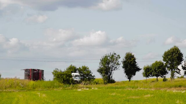   on the trailer of the truck the cultivator,transportation of a large cultivator on a truck trailer