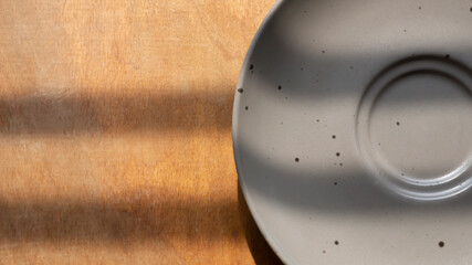 Gray empty plate with black dot texture top view on a wooden surface 