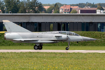 Delta winged modern fighter aircraft taxiing at an airbase.