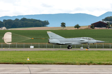Modern fighter jet aircraft landing with the assistance of a drogue chute to slow it down on the...