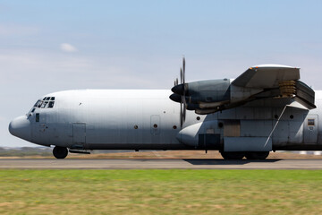Fototapeta na wymiar Military cargo airplane rolling down a runway in preparation for takeoff.