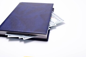 100 dollar bills lie in a blue notebook on a white background in close-up. A man's hand opens a notebook with dollars. Find, a stock for a rainy day dollars. Inheritance