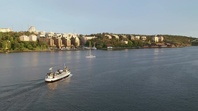 Torist boat sailing ont the water outside of Stockholm City. Passenger ferry during sunset. Staycation in the Swedish capital.