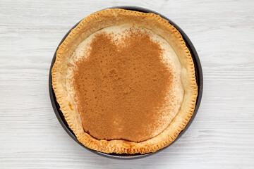 Homemade Sugar Cream Pie in a baking dish on a white wooden background, top view. Flat lay, overhead, from above.