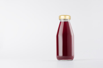 Violet berries juice in glass bottle with gold cap and white blank label mock up on white background with copy space, template for packaging, advertising, design product, branding.