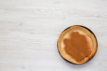 Homemade Sugar Cream Pie in a baking dish on a white wooden table, top view. Flat lay, overhead, from above. Copy space.