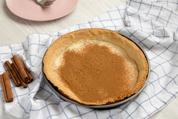 Homemade Sugar Cream Pie in a baking dish on a white wooden surface, low angle view.