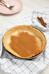 Homemade Sugar Cream Pie in a baking dish on a white wooden background, low angle view.