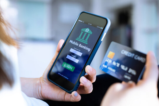 Mobile online banking concept.Close-up of Female hands using mobile phone and holding credit card