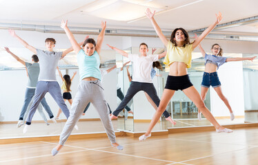 Obraz premium Group of cheerful tweens jumping during modern dances class