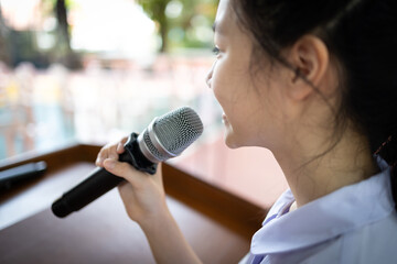 Asian child girl speaking with microphone voice speaker in seminar room,talk conference in...