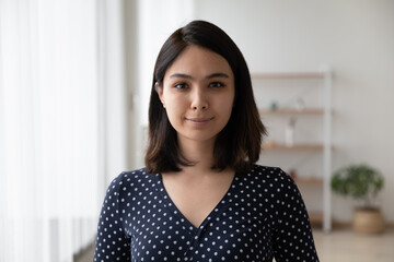 Profile picture of millennial Vietnamese girl renter tenant look at camera posing in own apartment or home, headshot close up portrait of smiling confident young Asian woman show leadership success