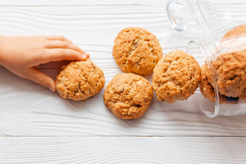 Homemade oatmeal cookies on white wooden table with milk on background