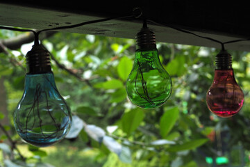 Kolorowe przezroczyste lampeczki na zielonym tłe