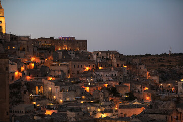 Fototapeta na wymiar Amazing lighted buildings in ancient Sassi district by night in Matera, well-known for their ancient cave dwellings. Basilicata. Italy