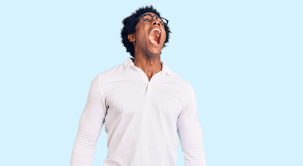 Handsome african american man with afro hair wearing casual clothes and glasses angry and mad...