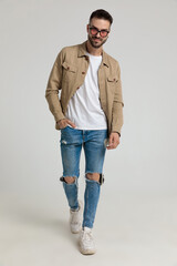 happy young casual man in jacket walking and smiling