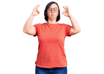 Brunette woman with down syndrome wearing casual clothes and glasses relax and smiling with eyes closed doing meditation gesture with fingers. yoga concept.