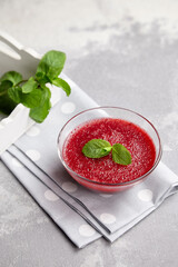 Sweet strawberry mousse in glass bowl with mint leaves, delicious summer dessert
