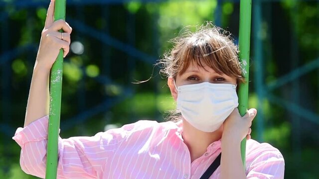 A young woman with a mask on her face protects herself from infection
