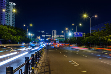 Night view of Sanya city with bright multi-colored illumination buildings, structures, roads,...