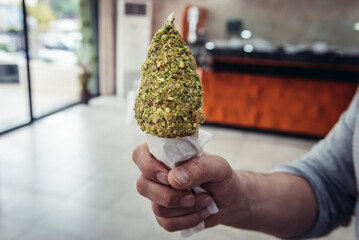 Man holding ice cream with pistachio nuts in Kousba town, Lebanon