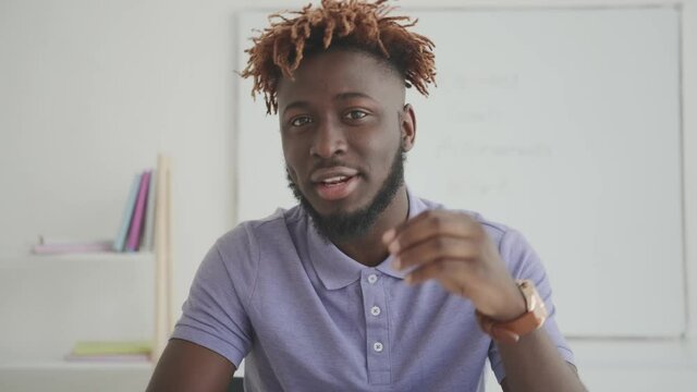 Charismatic cheerful afroamerican man speaks looking into the camera