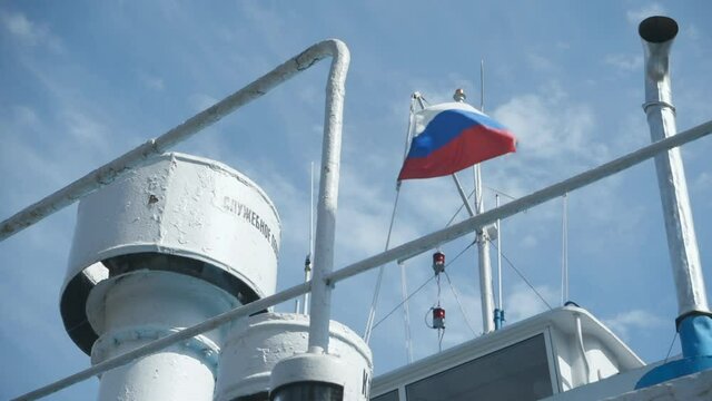 Ferry crossing on the Volga river. Russia, Tver region. Raising the Russian flag.