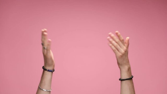 two hands curled in fists are dancing, wearing bracelets and rings, then the index fingers are dancing then the palms are moving around and giving a high five, clapping from side to side