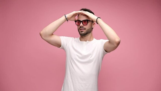 young sexy casual man listening to music, putting his hands on his head, starting to dance, pointing finger up, pointing to his ear, waving his hand, laughing, waving both hands