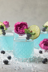 Blue soda.  Ice blue cocktail glass. Синий гавайский коктейль на белом фоне с лаймом. Blue curacao cocktail.  Blue drink with fruit garnish