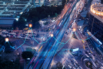 Financial stock chart hologram on top view of road, busy urban traffic highway at night. Junction...