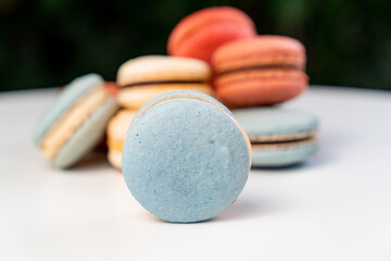multicolored macarons from natural ingredients and colors on white table.