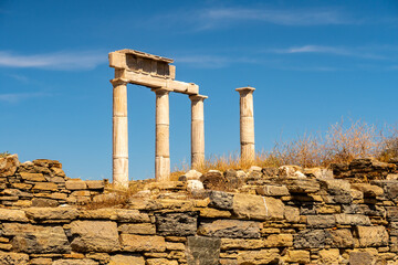 Antique doric columns and ruins on DELOS Island - mythological, historical, and archaeological site in Greece during sunny day with a blue sky.