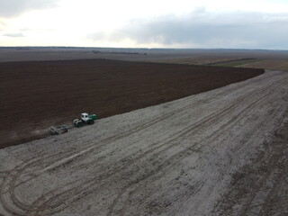 Tractor plows a field, aerial view. Agricultural landscape.