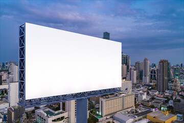 Blank white road billboard with Bangkok cityscape background at night time. Street advertising poster, mock up, 3D rendering. Side view. The concept of marketing communication to sell idea.