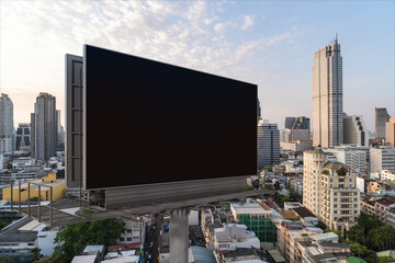 Blank black road billboard with Bangkok cityscape background at sunset. Street advertising poster, mock up, 3D rendering. Side view. The concept of marketing communication to promote or sell idea.