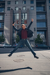 Cheerful man jumping with joy on the street